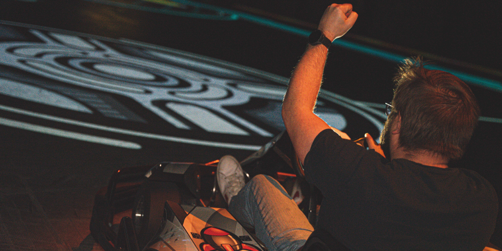 Joueur BattleFoot lève le bras lorsqu'il arrive avec son kart face au ballon virtuel